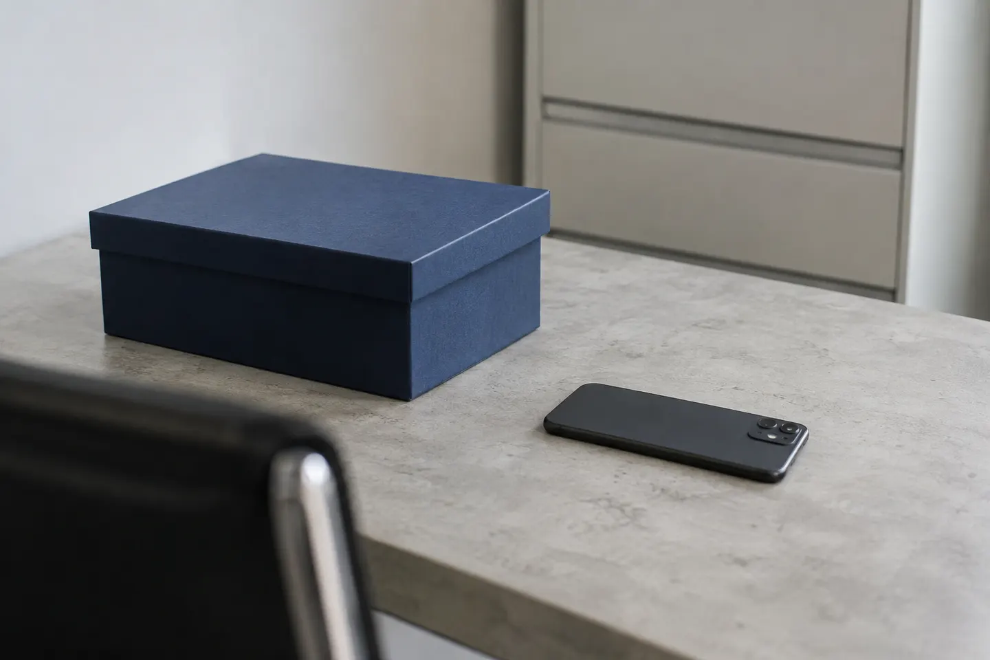 Caja de documentos cerrada junto a un teléfono boca abajo