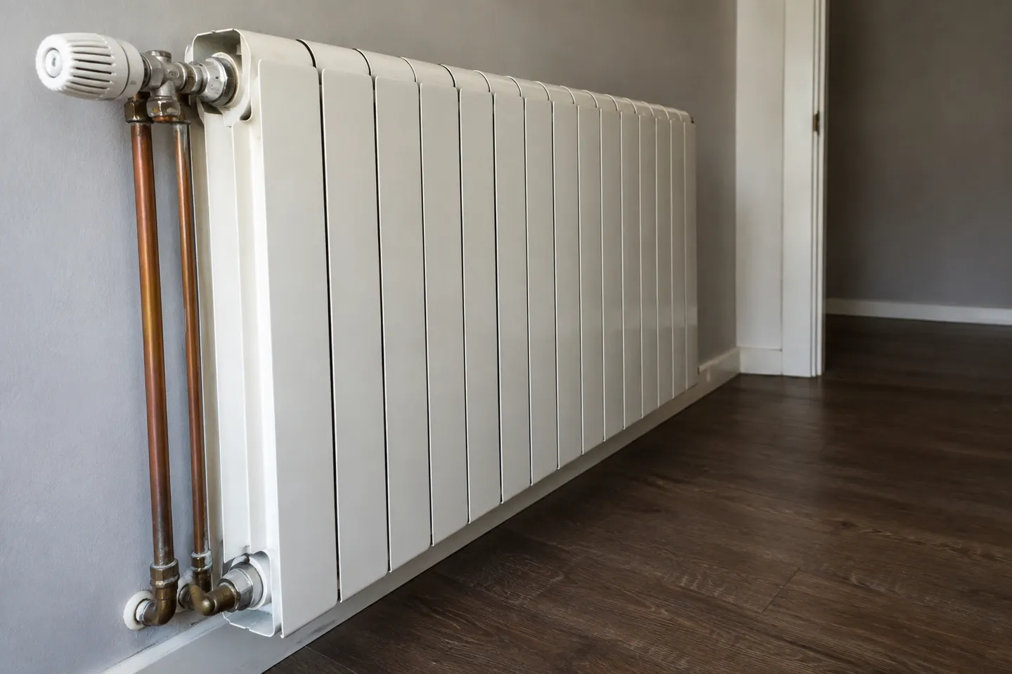 Radiador de aluminio con válvula termostática y conexiones de calefacción en una vivienda Radiador de aluminio con válvula termostática y conexiones de calefacción en una vivienda